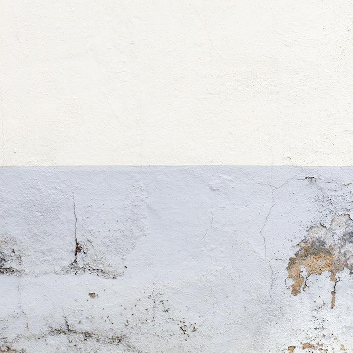 Parete con parte superiore pulita e parte inferiore danneggiata da muffa e condensa, da trattare con prodotti antimuffa San Marco Combat